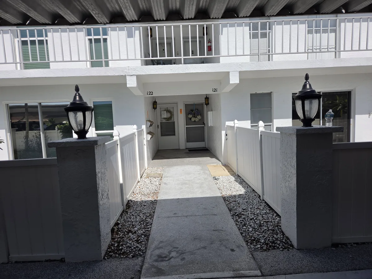 Bare stained concrete walkway at a Pinellas County condo community before coating
